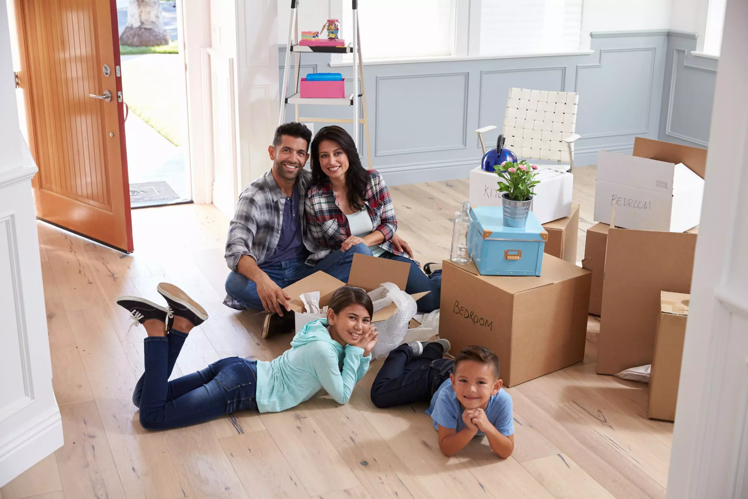 Portrait Of Hispanic Family Moving Into New Home